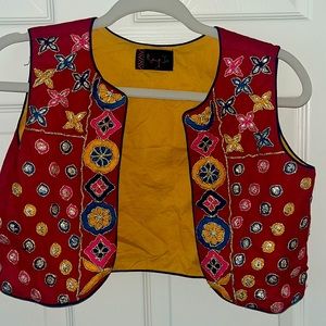 Colorful embroidered cropped vest with floral designs.